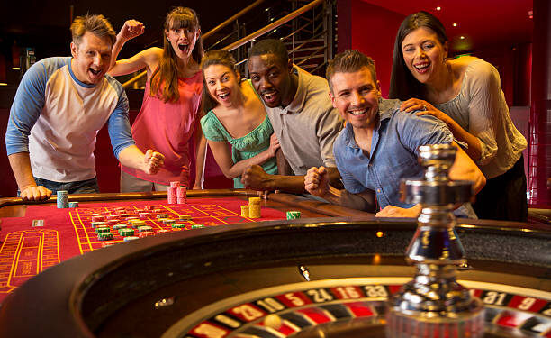 Group Of Friends Playing Roulette In Casino