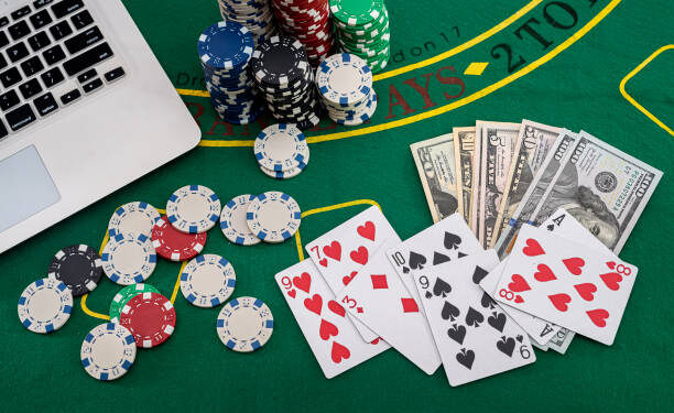 poker chips with banknotes placed on a laptop keyboard. Poker concept