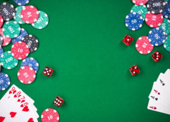 Casino games related items on green table, copy space.
