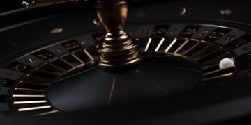 Modern Black And Golden Casino Roulette Wheel On Black Background. Close Up.