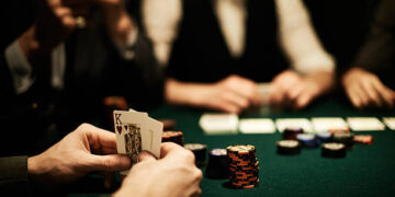 Hands of card player holding king of hearts